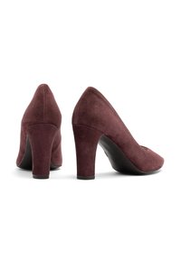 Burgundy velúr magassarkú cipők hegyes orral és texturált felülettel. Közepes blokk sarkú, elegáns kivitel, látható díszítések nélkül.