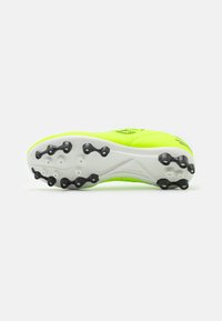 Voetbalschoen met een heldere neongele bovenkant, witte tussenzool en zwarte studs. Beschikt over een slank ontwerp en een gladde textuur.