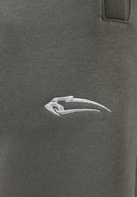 Jogginghosen aus olivgrünem Baumwollmischgewebe mit strukturiertem Strick. Mit einem weißen gestickten Logo auf der linken Seite.