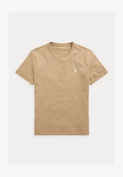 Bež kratka majica z okroglim izrezom in majhnim belim logotipom igralca polo na levi strani prsnega koša.