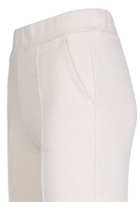 Haringbone-patroonbroek in lichtbeige met een elastische tailleband en zijzakken, gekenmerkt door een textuurstof en een op maat gemaakte uitstraling.
