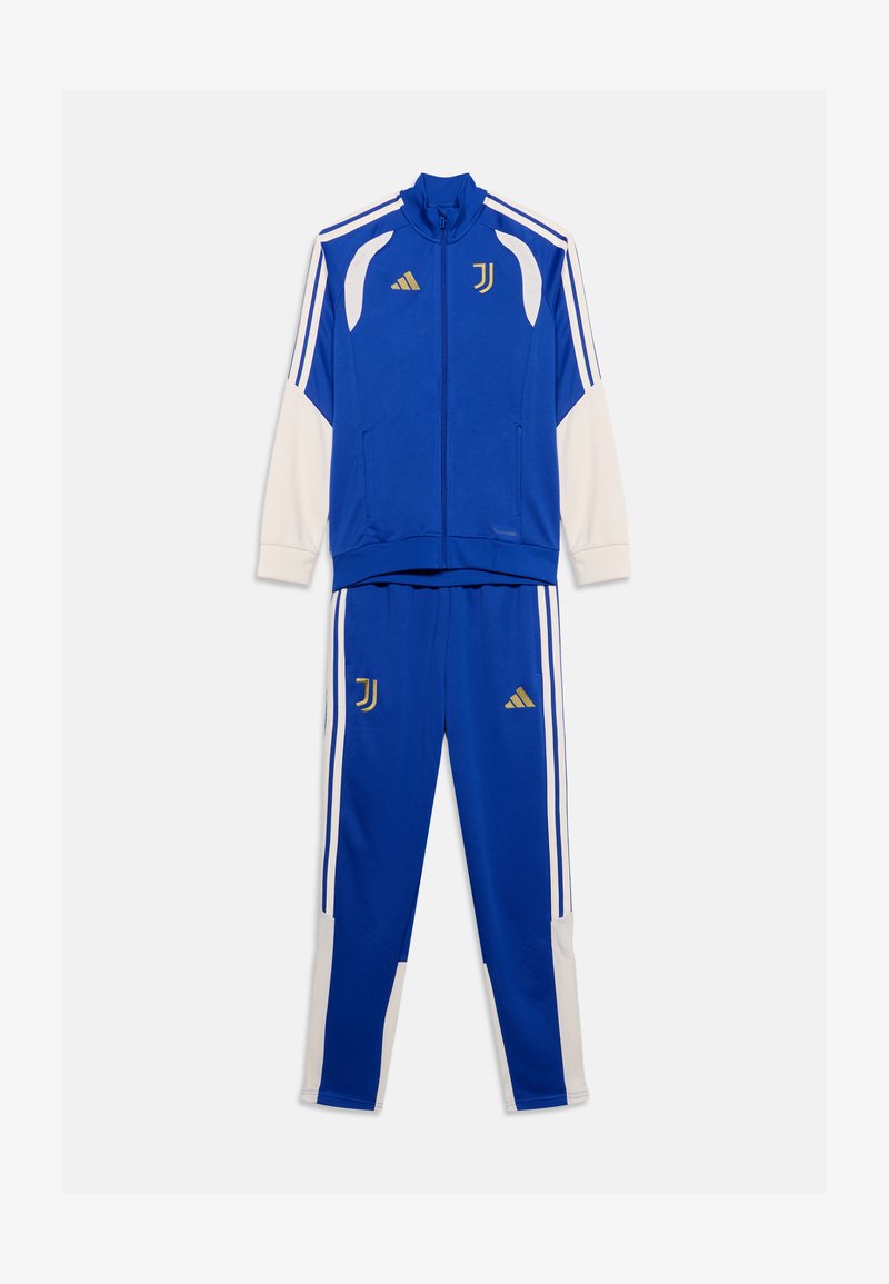 Survêtement Adidas Juventus bleu et blanc avec logos dorés, veste zippée et pantalon assorti sur fond blanc uni.