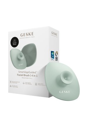 Brosse faciale guidée GESKE SmartApp avec support ventouse, poils en silicone doux, présentée avec un emballage mettant en avant les fonctionnalités de nettoyage 4 en 1 et de scan de la peau.