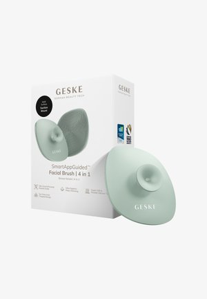 Brosse faciale guidée GESKE SmartApp avec support ventouse, poils en silicone doux, présentée avec un emballage mettant en avant les fonctionnalités de nettoyage 4 en 1 et de scan de la peau.