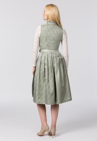 Ein grün gemustertes Kleid mit einem taillierten Oberteil und einem plissierten Rock. Das Kleid hat einen Satin-Gürtel und lange Spitzenärmel. Leichter, strukturierter Stoff.