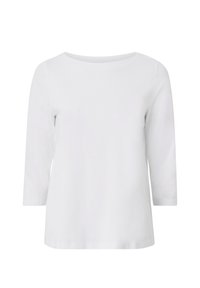 Blusa blanca de manga tres cuartos hecha de suave algodón. Cuenta con un escote redondo y una textura lisa y sin adornos. Diseño minimalista.