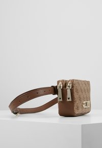 Hnědá texturovaná kabelka se dvojitým zipem, vybavená zlatými kovovými doplňky a odnímatelným popruhem. Vzor monogramu na látce.