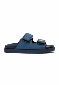 Sandale mules bleue avec deux sangles en tissu ajustables et une semelle plate texturée pour un usage décontracté.