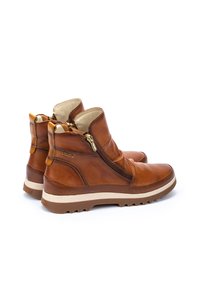 Bruine leren enkelboots met ritsen, met een gestructureerd oppervlak, ronde neus en een contrasterende crèmekleurige buitenzool.