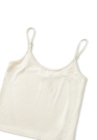 Top de tirantes finos en color beige, con escote redondeado y una textura suave y lisa. La tela es ligera y elástica.