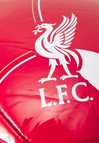 Hvid liver bird logo med "L.F.C." bogstaver på en rød, skinnende overflade, sandsynligvis sportsudstyr eller merchandise.