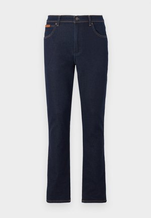 Donkerblauwe jeans met rechte pijpen, een voorste knoop en rits, voor- en achterzakken en bruine stikseldetails.