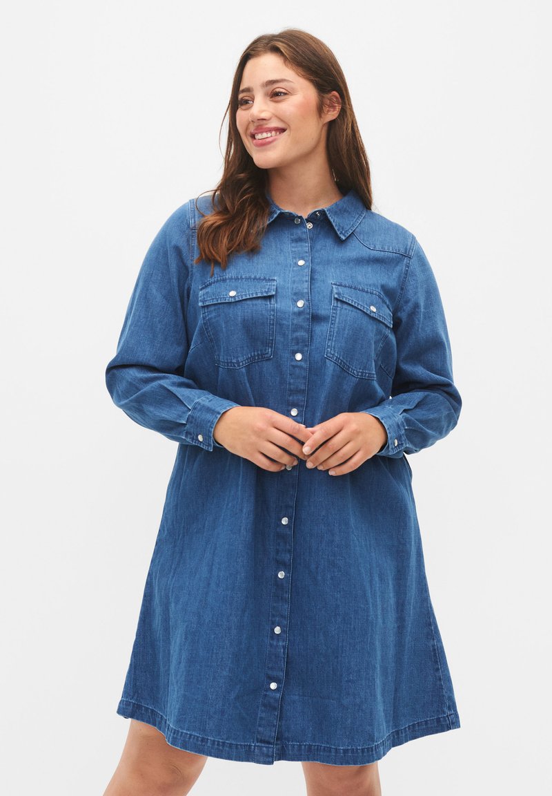 Jeanshemdkleid in Dunkelblau, mit Knopfleiste, zwei Brusttaschen, langen Ärmeln und einer lässigen Silhouette, mit abgerundetem Saum.