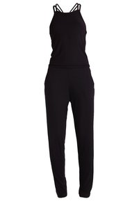 Combinaison noire avec fines bretelles croisées, taille élastique et poches latérales. Fabriquée en tissu doux et extensible pour le confort.