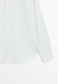 Camicia a righe in azzurro chiaro e bianco, con chiusura a bottoni sul davanti, maniche lunghe e orlo curvo. Tessuto morbido, sottili righe verticali.