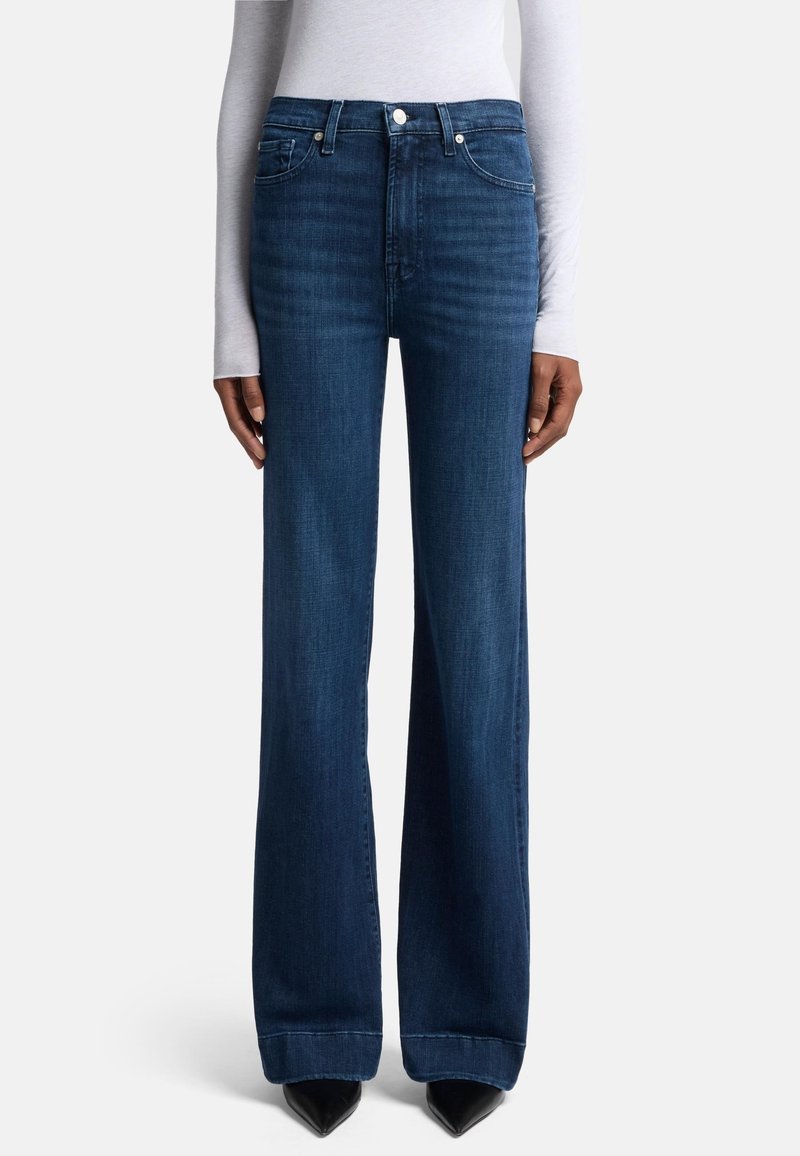 Jean large bleu foncé avec taille haute, présentant une fermeture à bouton et à zip, un design à cinq poches et un léger dégradé sur les jambes.