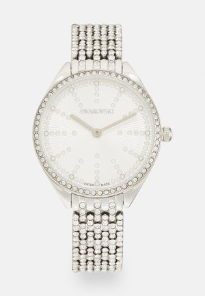 Swarovski silberne Uhr mit einem strukturierten weißen Zifferblatt, das mit Kristallen verziert ist, und einem flexiblen Armband, das mit Kristallen akzentuiert ist.