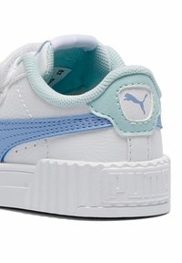 Biały sneaker z jasnoniebieskimi akcentami, chropowata skórzana cholewka, wyściełany kołnierz i żłobiona gumowa podeszwa. Na pięcie znajduje się logo Puma.