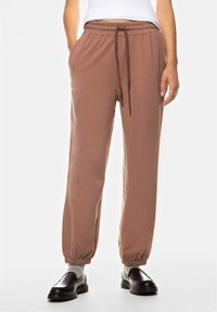 Bruine joggers met een elastische tailleband, zijzakken en elastische boorden. Gemaakt van zachte stof, met een trekkoord voor een verstelbare pasvorm.