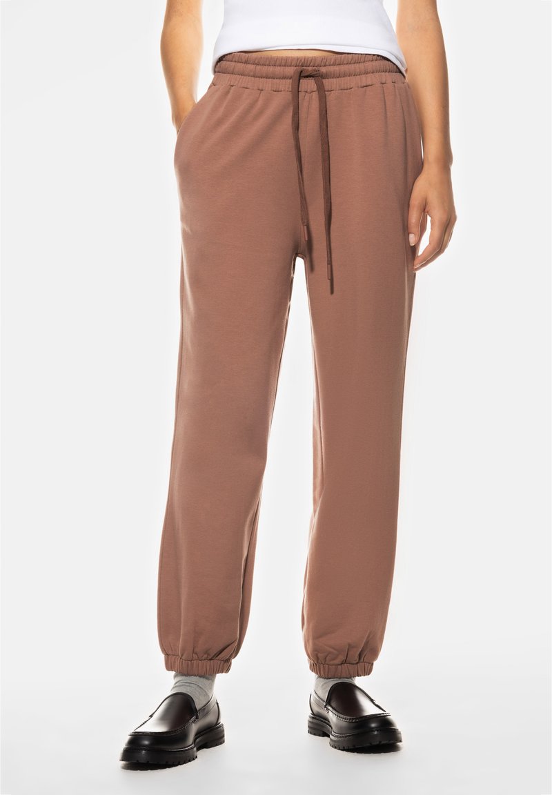 Bruine joggers met een elastische tailleband, zijzakken en elastische boorden. Gemaakt van zachte stof, met een trekkoord voor een verstelbare pasvorm.