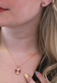 Collana in oro rosa con ciondolo a forma di trifoglio con foglie lisce e texturizzate. Orecchini a bottone a forma di trifoglio in oro rosa coordinati.