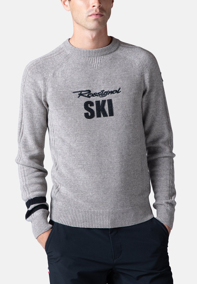 Maglione grigio con scollatura e polsini a coste, con il logo "Rossignol SKI" in nero. Realizzato in materiale a maglia testurizzata.