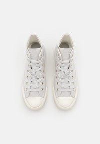 Høye sneakers i lys grått stoff med gullhull og hvite gummisåler. Har lissene og en teksturert overdel.