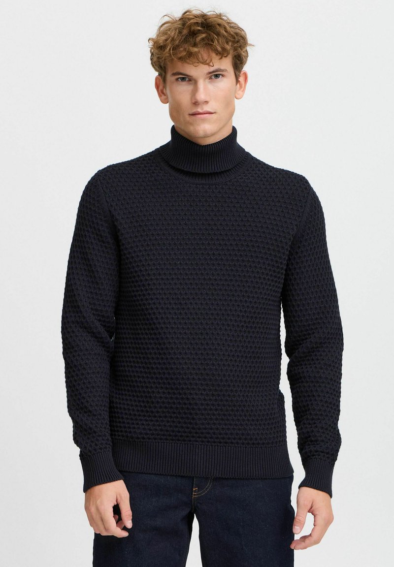 Maglione a collo alto lavorato a maglia di colore blu navy con motivo testurizzato, polsini e orlo a coste. Realizzato in un materiale morbido.