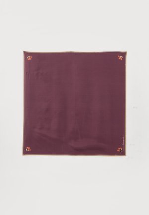 Tissu carré violet foncé avec petite broderie de fleur rouge à chaque coin et une bordure beige cousue.