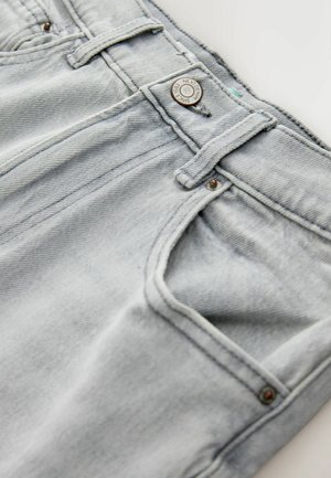 Lichtblauwe denim jeans met een verweerde textuur, knoopsluiting en gestikte voorzakken. Heeft zichtbare stiksels en metalen accenten.