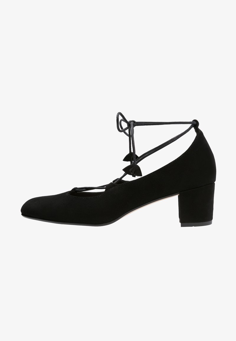 Chaussure noire en daim à talon bloc bas, bout fermé et brides croisées à nouer à la cheville, vue de profil.