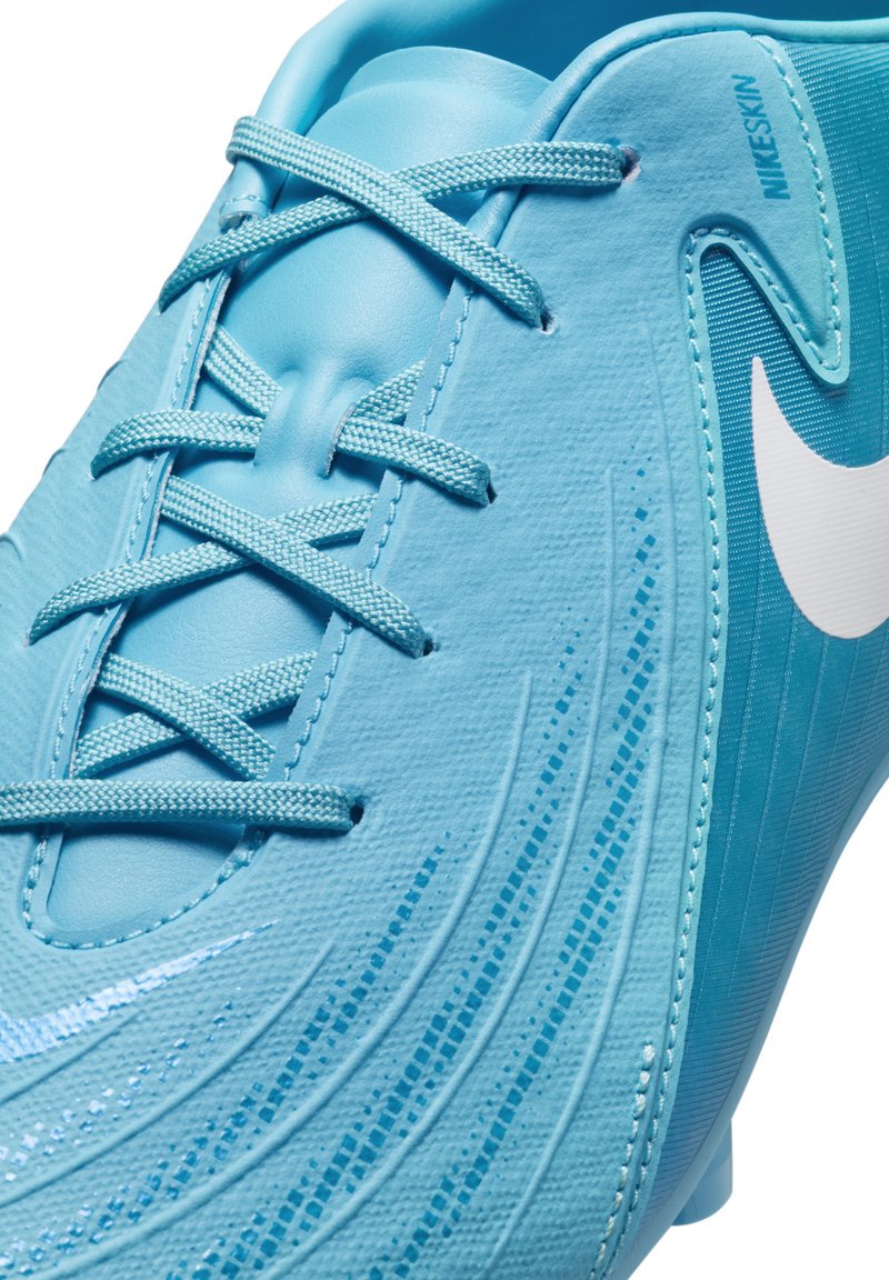 Chaussure de football bleu clair avec un dessus en synthétique texturé, lacets ton sur ton, motifs en vagues distinctifs et un logo Nike blanc sur le côté.
