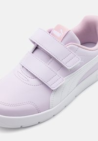 Baskets violettes claires avec une surface texturée et des accents blancs. Comprend des sangles en Velcro ajustables et un col rembourré pour le confort.