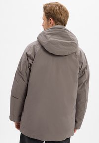 Grijze geïsoleerde jas met een capuchon, met een gladde textuur en een iets verlengde achterkant. Het ontwerp is ontspannen en eigentijds.
