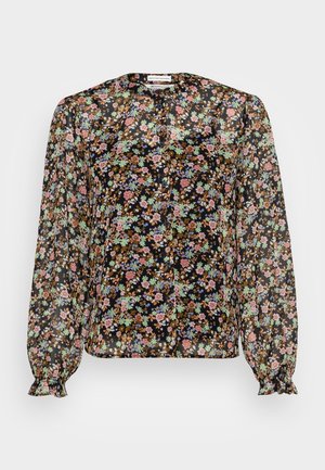 Blouse noire transparente à manches longues bouffantes et petit motif floral multicolore, avec patte de boutonnage devant et poignets volantés.
