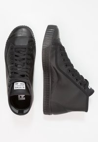 Czarne trampki typu high-top z gładką skórzaną cholewką, teksturowaną gumową podeszwą i okrągłym noskiem. Posiadają płaskie sznurowadła oraz znak firmowy na języku.