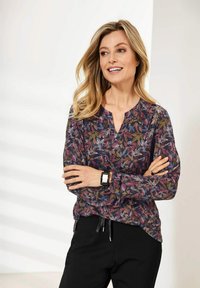 Langärmlige Bluse mit Blumenmuster in Dunkelblau, verziert mit mehrfarbigen Blattmotiven, mit einem V-Ausschnitt und lockerer Silhouette. Enthält eine Kordelzugdetails.