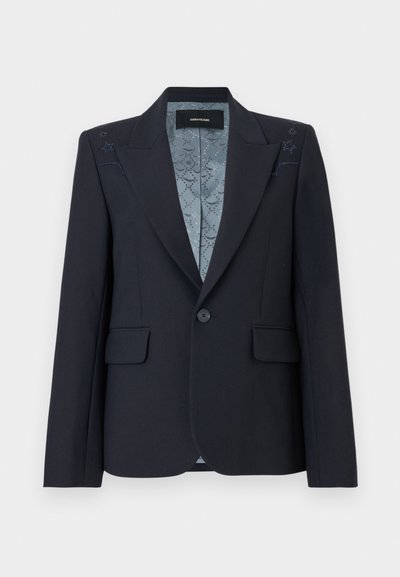 Μαύρο ραμμένο σακάκι με ένα κουμπί, τσέπες με καπάκι, πέτο με εγκοπές, λεπτές διακοσμήσεις με αστέρια στους ώμους και εσωτερική φόδρα με σχέδιο.