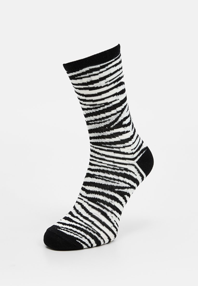 Calcetines de rayas blancas y negras hechos de un material suave y elástico. Presentan un puño acanalado y acentos de color negro sólido en los dedos y el talón.