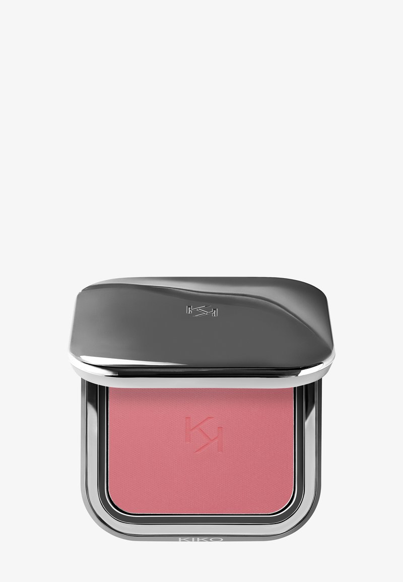 Kompakter Rouge in einem glänzenden silbernen Gehäuse, mit einem weichen rosa Puder im Inneren, das ein geprägtes Logo und einen polierten, geschwungenen oberen Bereich aufweist.