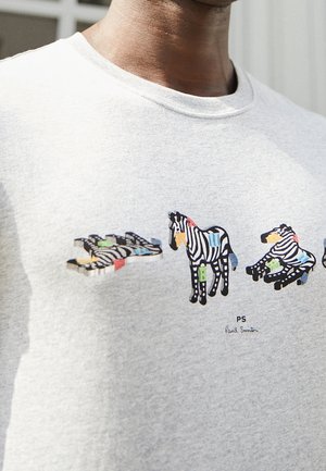Grå sweatshirt med et farverigt zebra grafikdesign, hvor fire zebraer er afbildet i forskellige positioner og mønstre. Signatur "PS Paul Smith" trykt nedenfor.