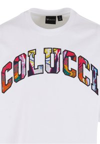 White crew neck T-shirt with "COLUCCI" in large, multicolored, patterned letters embroidered across the chest.