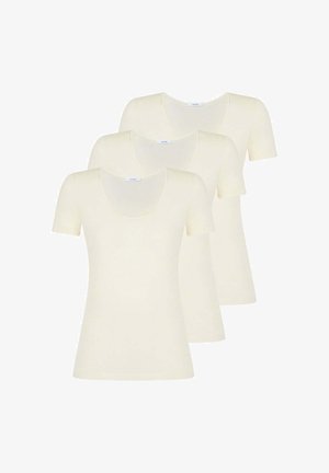 Tre semplici t-shirt crema a maniche corte con scollature arrotondate, impilate e sovrapposte su uno sfondo bianco.