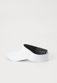 Visera deportiva blanca hecha de tejido ligero, con un ala curvada, forro interno negro y un logo de Nike en la parte delantera.