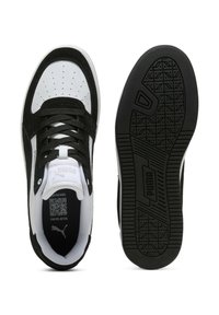 Zapatillas negras y blancas con materiales de ante y malla, caja de dedos perforada, cordones planos y suela de goma con un agarre texturizado.
