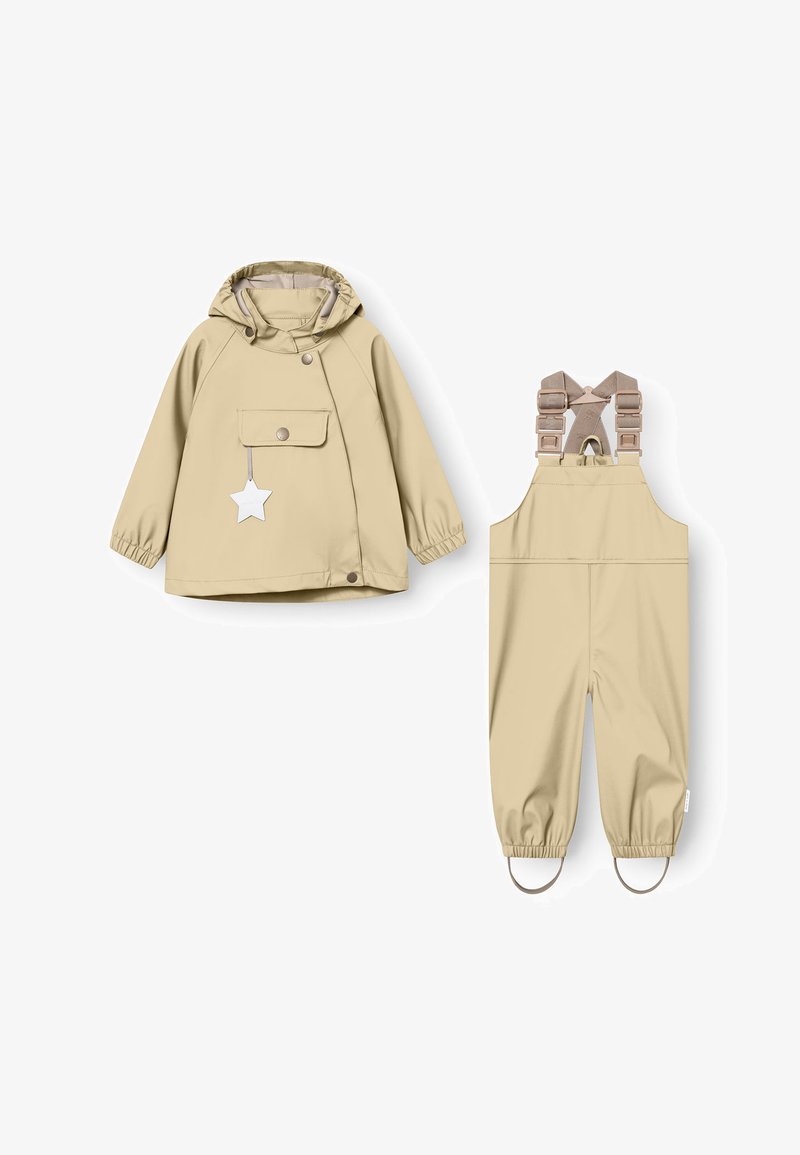 Beige rain jacket with a hood, front pocket, and snap closure, paired with beige overalls featuring adjustable straps and elastic cuffs.