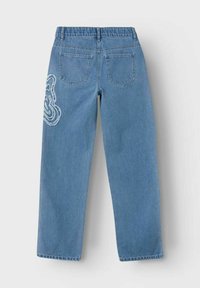 Světle modré denimové džíny s volným střihem, s zadními kapsami a dekorativním výšivkovým designem na levém boku.