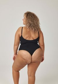 Czarny jednoczęściowy strój kąpielowy z cienkimi, regulowanymi ramiączkami i wysokim wycięciem. Gładka faktura, minimalistyczny design oraz dopasowany krój podkreślający kontury ciała.