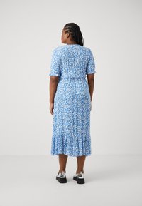 Μπλε φόρεμα με λουλούδια, κοντά μανίκια, ραντάκι στο τελείωμα και στενή μέση. Φτιαγμένο από ελαφρύ ύφασμα, έχει μικρά λευκά λουλούδια σε μπλε φόντο.