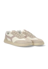 Zapatillas de ante beige y crema con una silueta baja, que presentan acentos en rosa claro y una suela de goma texturizada. Diseño con cordones y cuello acolchado.